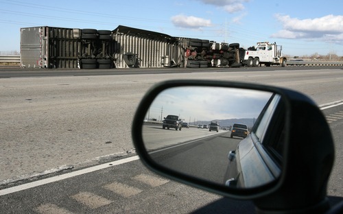 Steve Griffin  |  The Salt Lake Tribune
A semitractor trailer lies on its side after being blown over by high winds on I-15 near Centerville on Thursday.
